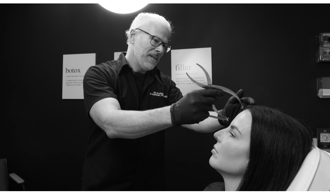 Mike Kelleher assessing facial proportions — (R)Evolution MedSpa
